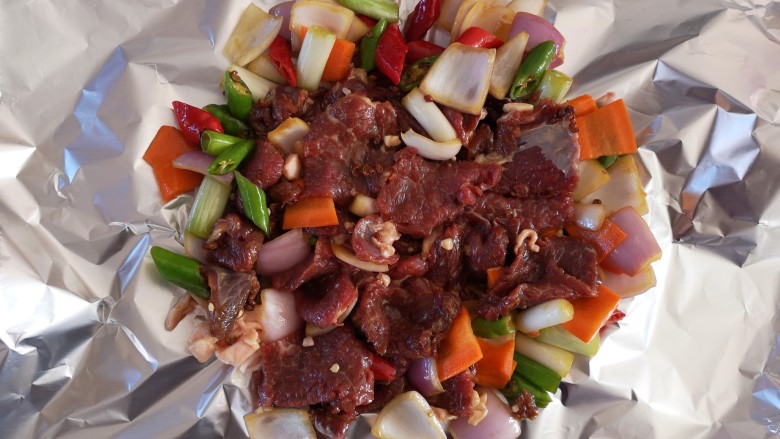 电磁炉版锡纸牛肉,取一张锡纸,将腌制好的牛肉倒在上面