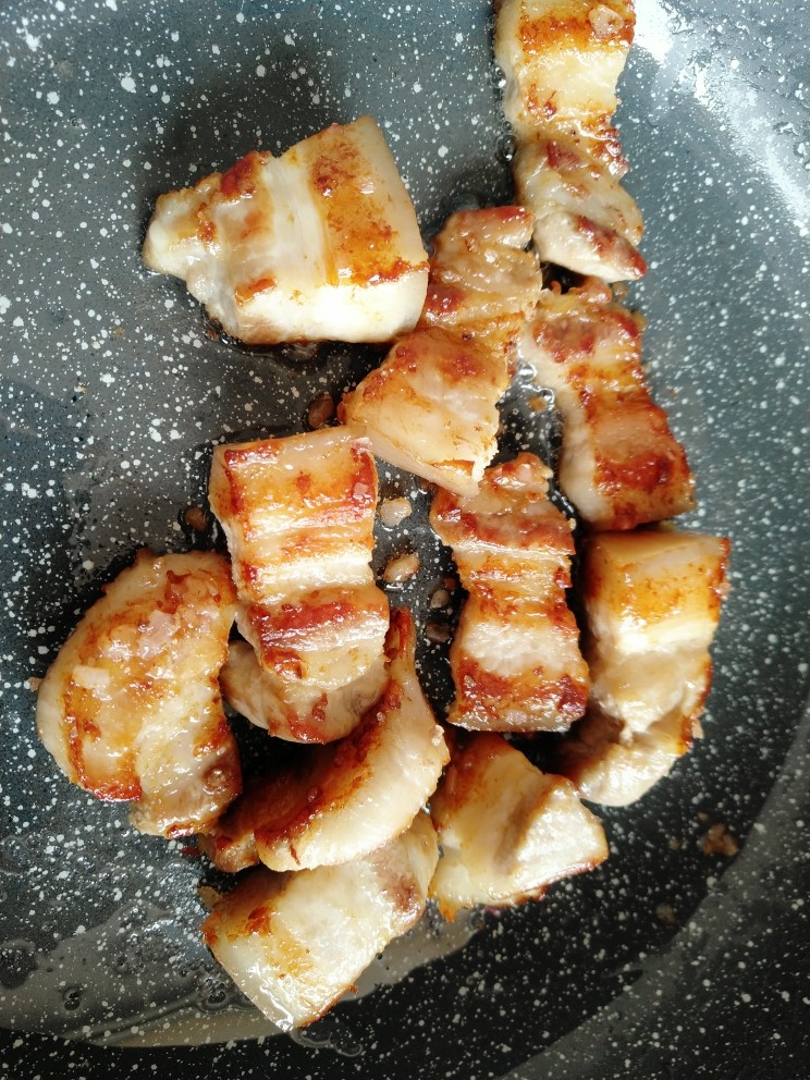 红烧肉烧冬瓜,冰糖融化的过程中，五花肉里的多余油脂也会继续被煸炒出来。冰糖融化后 用铲子翻拌均匀。