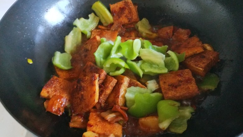 新文美食 红烧冻豆腐,在加入尖椒炒均匀,出锅前放入适量鸡粉炒均匀即可。