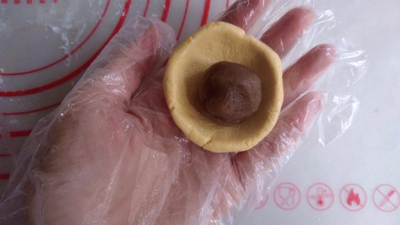 南瓜蒸月饼,分成12个,每个35克的小剂子,馅料分成每个15克,搓圆备用。未操作的糯米粉团先盖上保鲜膜,防止风干,将小剂子压扁后放入馅料