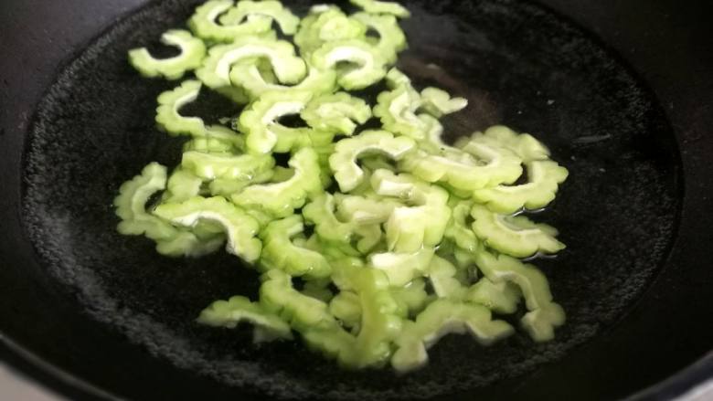 苦瓜炒虾仁,锅中入水,加两滴油和适量盐,水开后放入苦瓜焯1分钟,捞出沥干水份