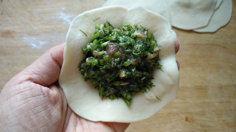 米粥、包子一锅出,蒸笼砂锅的妙用,面团分成大小均匀的面剂,约25克~30克一个的剂子,不要太大,我们做的是小笼包。擀成边缘薄,中间厚的皮。取一个皮,加入适量馅,包成包子