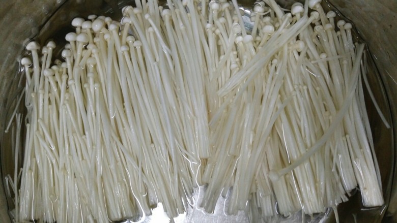 夏天开胃小菜~凉拌金针菇,锅内放入适量清水,放入适量盐烧开再倒金针菇焯水一分钟。