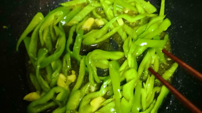 青椒肉丝,觉得锅里的油多就不用放油了,各位自己看实际情况,放青椒,中火,炒至青椒颜色稍深,放蒜,炒出香气