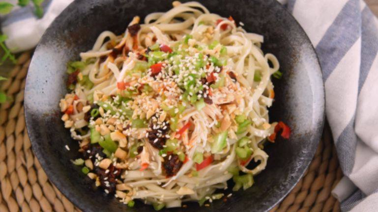 夏季四川最热卖的美食之一,家庭懒人做法——川味鸡丝凉面,将面捞入碗底,放上浇头拌匀即可