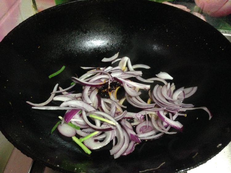 韭菜鸡蛋炒粉丝,热锅凉油倒入洋葱丝和辣豆豉,炒散炒匀,炒出香味