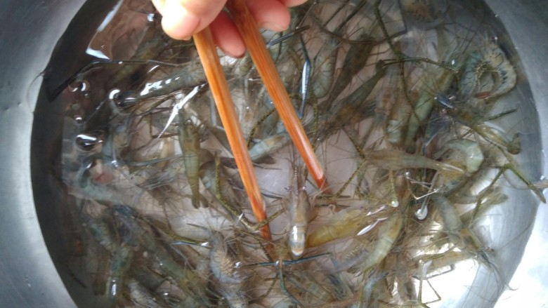 韭苔爆河虾,河虾买回来马上冲洗两次,可以借助筷子搅洗,避免手被扎到。