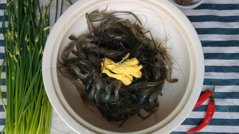 韭苔爆河虾,洗好后控干水分,盛放到盘子里,<a style='color:red;display:inline-block;' href='/shicai/ 2800'>生姜</a>用刀背拍扁,与河虾同放。
