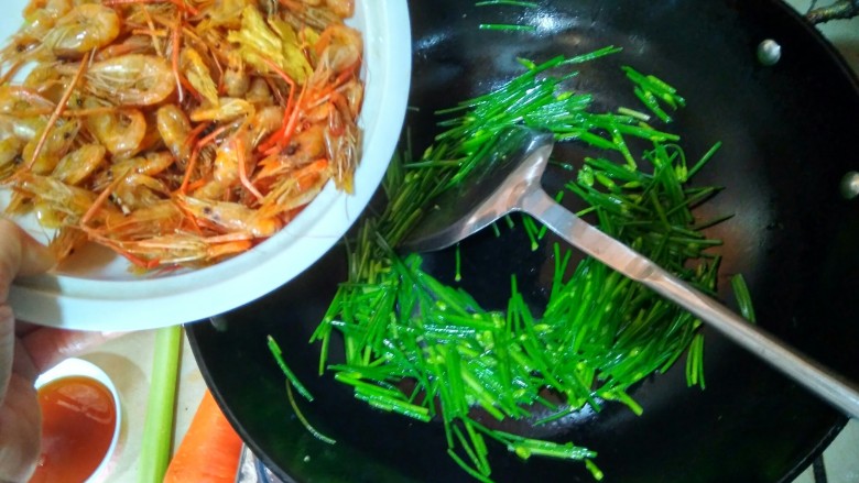 韭苔爆河虾,倒入河虾翻炒两三下后,倒入酱汁一同翻炒,上色均匀后即可关火出锅。