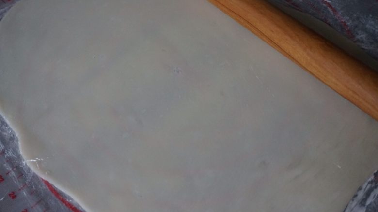 冰皮蔓越莓蛋糕,冷藏松驰过的冰皮取出,放在两张保鲜膜中间,擀成长方形(为防止粘,在里面撒一些熟糕粉