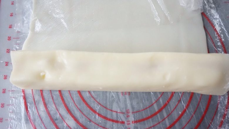冰皮蔓越莓蛋糕,冰皮贴着蛋糕卷起,切断。再做下一份蛋糕条,这块擀开的冰皮足够做两份蛋糕条