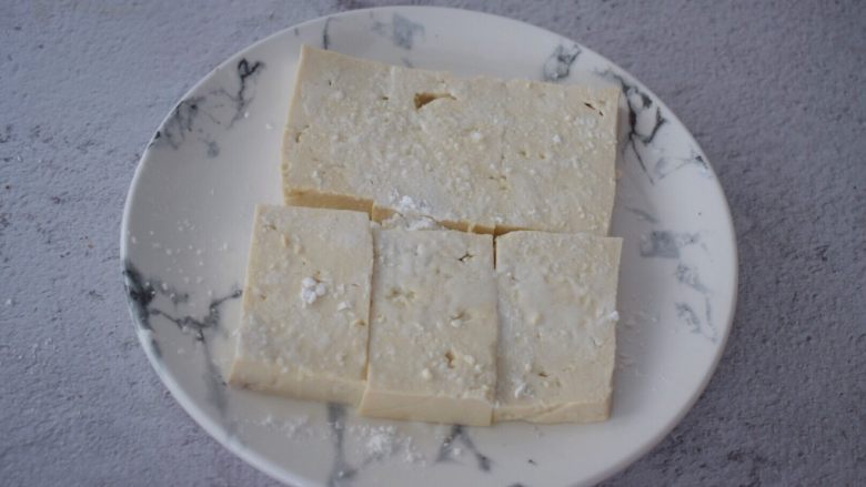 锅塌豆腐,豆腐切成长方块,加入少许盐抹匀,再在表面裹上淀粉备用