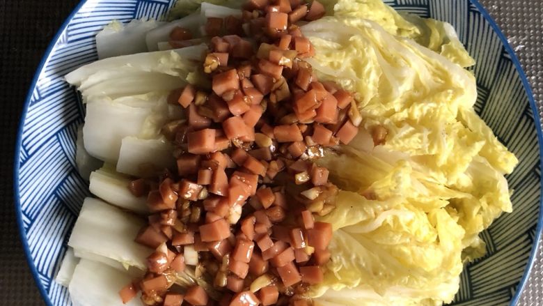 微波炉懒人娃娃菜,将微波炉里面的娃娃菜取出,翻动一下。淋上小碗中刚刚做好的火腿肠姜蒜沫。再次将娃娃菜放入微波炉大火加热3-4分钟。PS:可根据喜爱的熟烂程度调整时间哟!