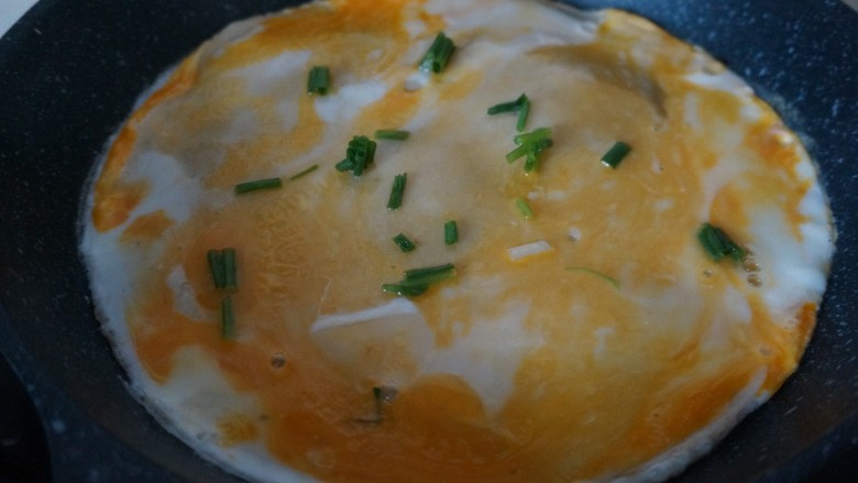 伪版煎饼果子,倒入一半的面糊,打上一个<a style='color:red;display:inline-block;' href='/shicai/ 9'>鸡蛋</a>戳破撒上小葱末