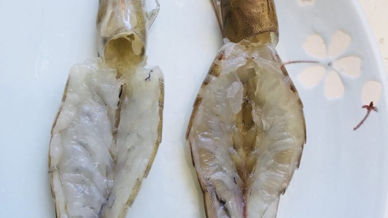 双花芒果焗大虾,大虾洗净剪去须和角还有腿,背部剖开挑出虾线。
