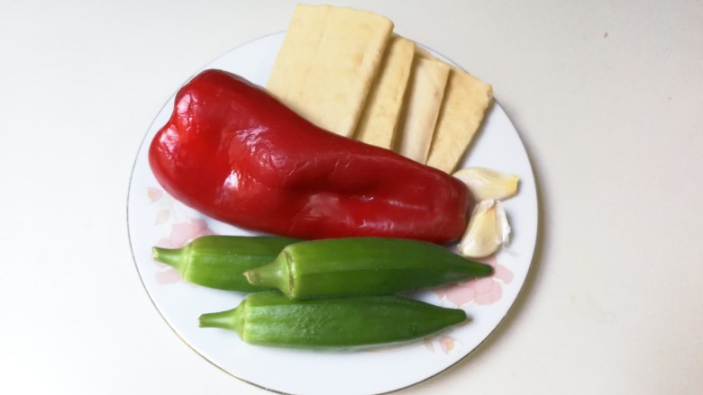 红椒秋葵白香干,准备好所有食材:四块白香干,一个红椒,三个<a style='color:red;display:inline-block;' href='/shicai/ 70'>秋葵</a>,两瓣蒜