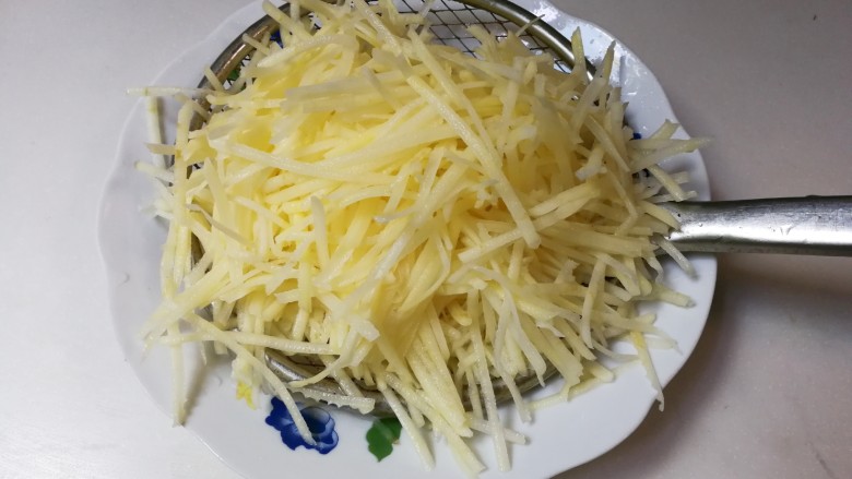 蒜香土豆丝,洗去淀粉,捞起来沥干水