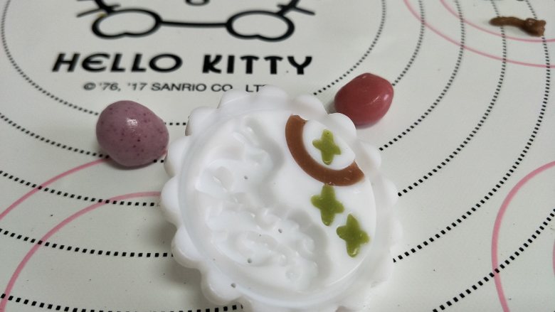 五彩冰皮月饼,月饼界的颜值担当,取出一个模片,稍微撒些熟的糯米粉,轻薄的一层。用颜色的面团填充图案。注意图案的可见面不可以沾到熟糯米粉。