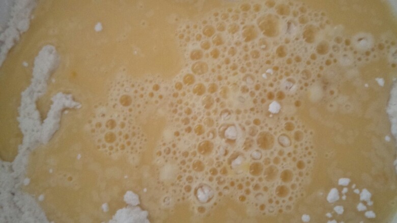 面粉粑粑,把蛋倒入面粉里搅拌。