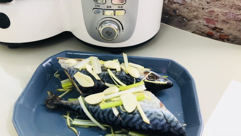 清蒸鲅鱼,取一深盘 铺准备好 葱姜蒜 鱼的上下 鱼肚子里面都要放 撒上<a style='color:red;display:inline-block;' href='/shicai/ 718'>料酒</a>