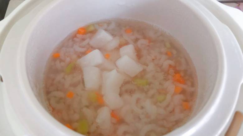 【宝宝辅食】鳕鱼燕麦米粥,接着放入鳕鱼块,再熬制15分钟,出锅前放入西芹叶,继续煮1分钟即可