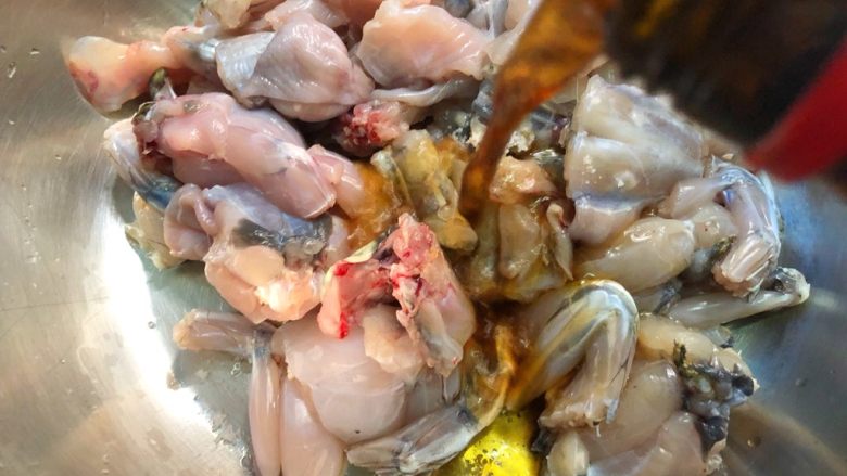 香辣口水蛙,牛蛙放入碗里,倒入10g料酒