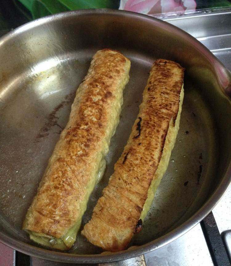 虾仁腐皮卷,起油锅加少量油,油微热将腐皮卷下锅用中小火边煎边滚动腐皮卷,煎至表面金黄即可