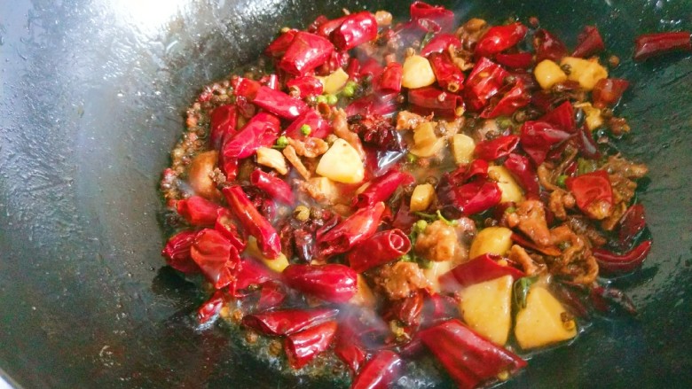 新文美食 川味椒香麻辣鸡块,倒入<a style='color:red;display:inline-block;' href='/shicai/ 86474'>干辣椒</a>,姜片,蒜瓣