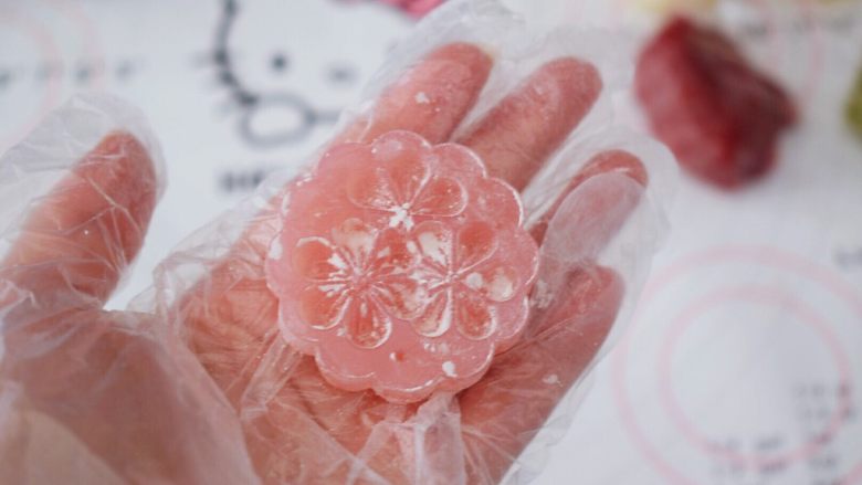 冰皮月饼,先取一片学厨月饼花片,表面撒上熟粉