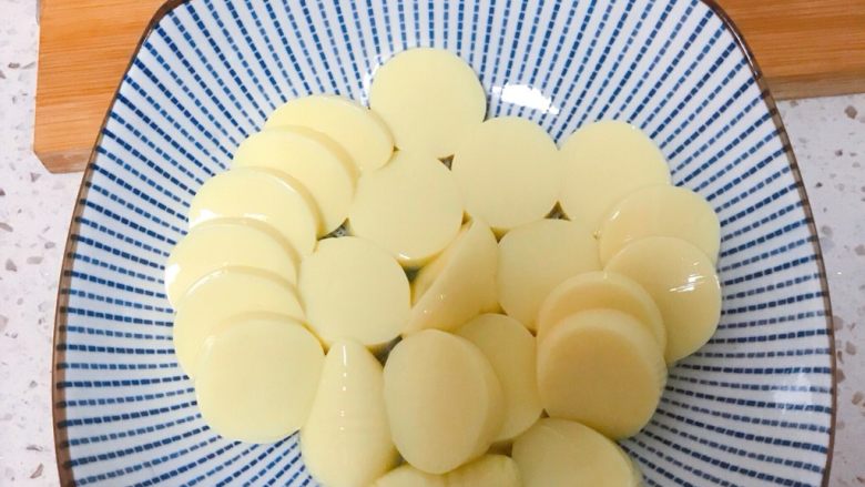 🌾金针菇烧日本豆腐,🍴将<a style='color:red;display:inline-block;' href='/shicai/ 477'>日本豆腐</a>连包装袋一起从中间切断,轻轻挤出豆腐条,切成片。