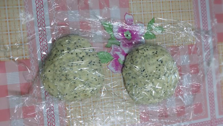 这是一款无需揉面零失败、菜鸟也能轻松驾驭的黑芝麻面包,分割成两小份,盖上保鲜膜松弛15分钟