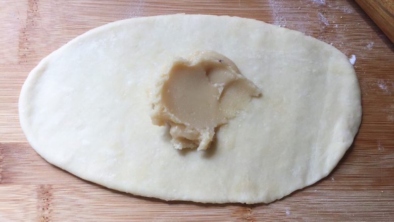 奶香盘丝饼,揉圆,先擀成长牛舌状,放上油酥,抹匀