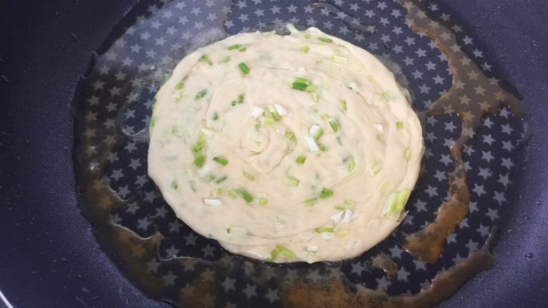 葱油盘丝饼,锅里放油,饼胚入锅、煎至二面金黄后出锅