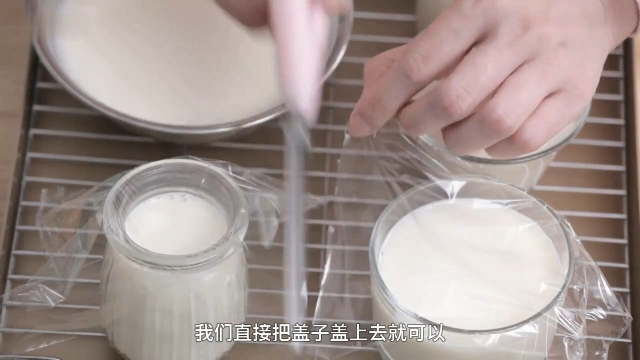 自制酸奶,将酸奶倒入器皿中,盖上保鲜膜进行发酵。