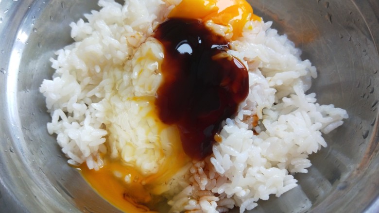 新文美食 香肠耗油炒饭,米饭倒入盆中加入一个鸡蛋,耗油。