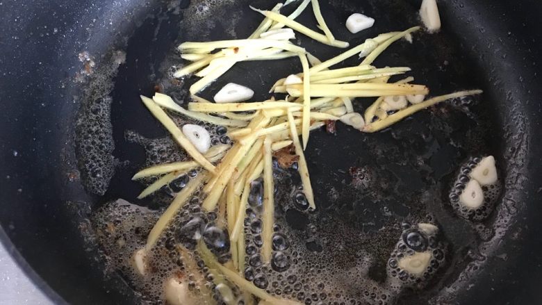 芽芽私房菜~辣炒梭子蟹,锅内留底油,下生姜丝和大蒜片,小火煸香