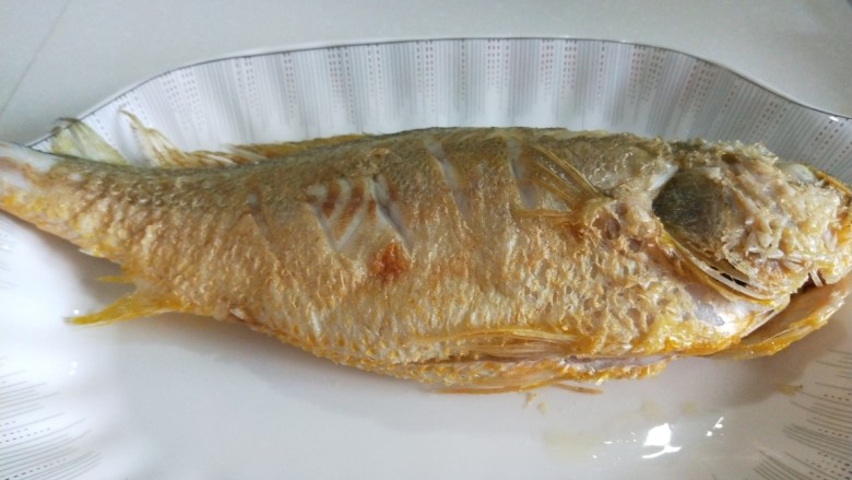 新文美食 红烧黄花鱼,放入盘中,在炸制第二条。