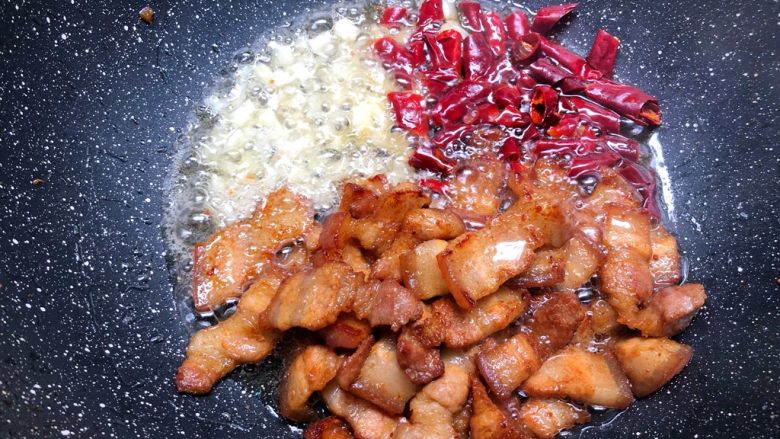 干锅豆角,五花肉煸炒出油以后,把肉拨到一边,放入干辣椒和蒜头爆香