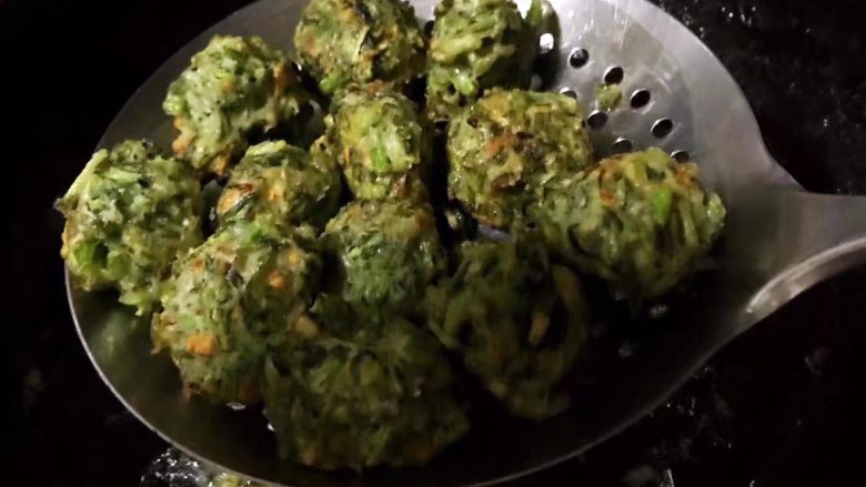 酥炸茼蒿丸,用笊篱将美味的茼蒿丸子盛出沥油