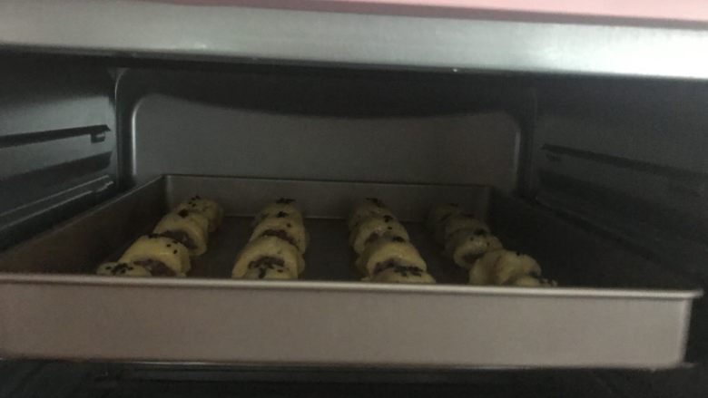 宝宝零食必备~奶香豆沙一口酥,放入提前预热到180度的烤箱中层,上下火180度烤20~25分钟。