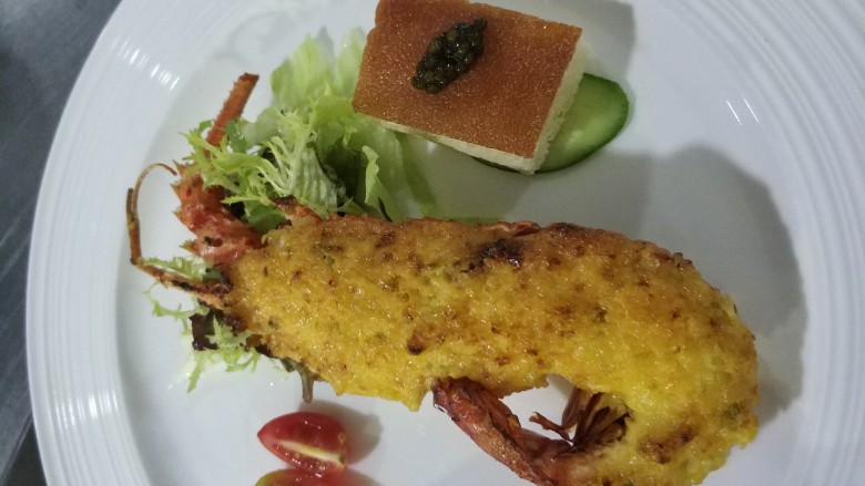 金沙汁焗小青龙,将龙虾劈两半。肉的一面在锅里把水分煎干,金沙酱涂抹均匀,烤箱烤6分钟即可