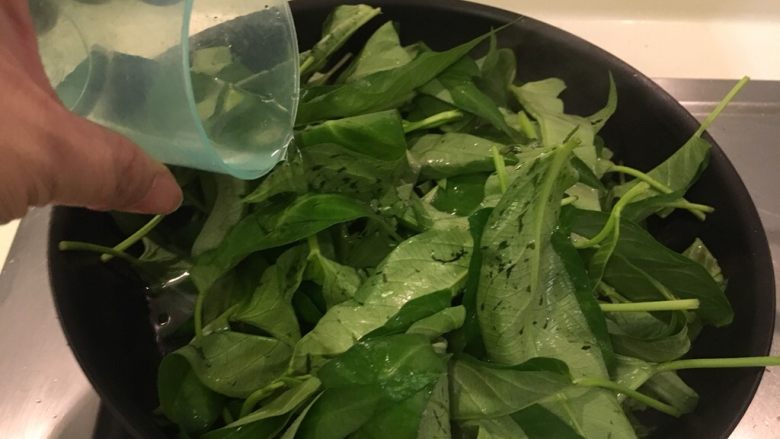 沙茶牛肉炒空心菜,空心菜放入锅里,加点水