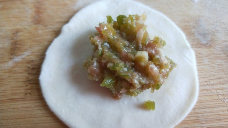 新文美食 菊花生煎饺,擀成饺子皮放入馅料。