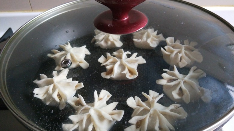新文美食 菊花生煎饺,盖好锅盖,小块煎制10分钟。