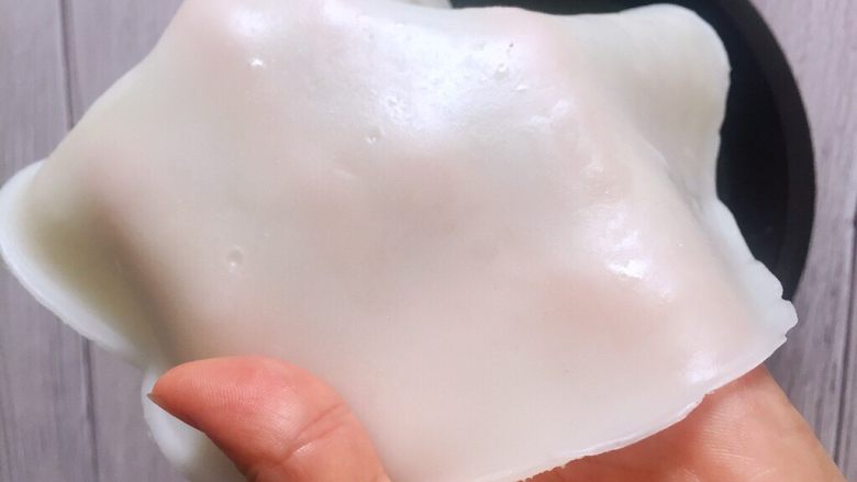 家庭简易版米皮,当降到不烫手就可以把米皮从盘子上脱模后,表面刷熟油放粘