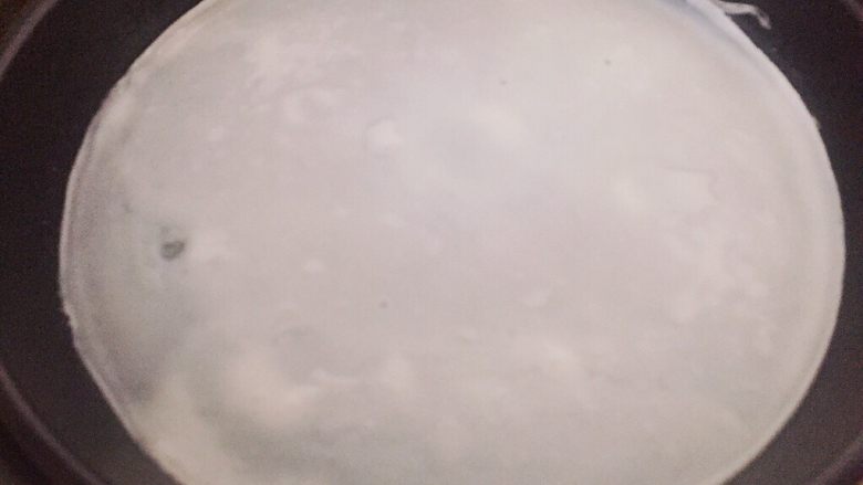 家庭简易版米皮,米皮表面有鼓起大泡,说明已经做好了,移出盘子入冷水盆降温