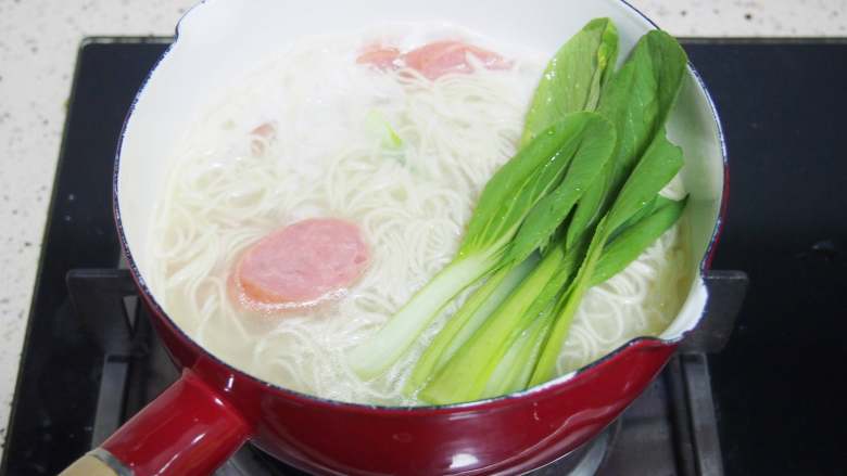 快手蔬菜汤面,面条煮好后放入适量盐,加入青菜