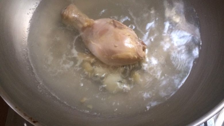 泰国鸡饭,鸡腿洗净,一锅水后放入蒜和姜和胡椒粉烧开后放入鸡腿,煮熟。