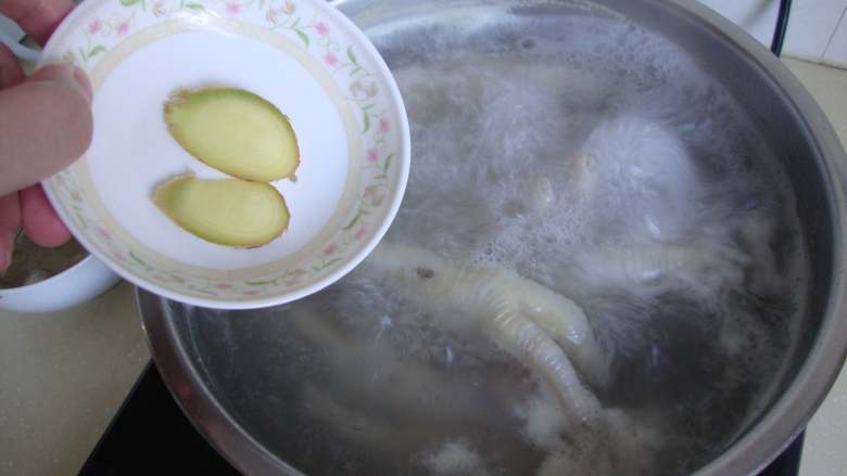 蒜香凤爪,凉水把鸡爪煮开,去血沫,加料酒、姜片煮20分钟