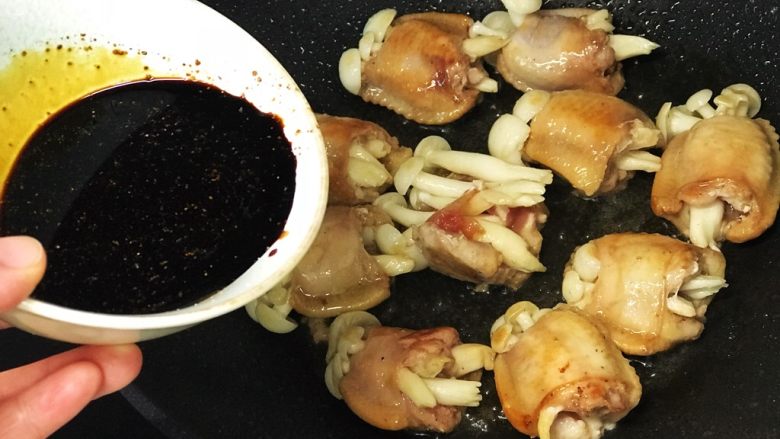红烧鸡翅白玉菇,鸡翅煎至双面金黄后倒入浇汁(中间一个鸡翅崩开啦);